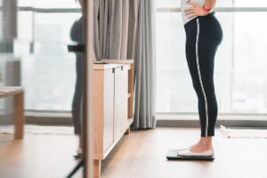 woman standing on a scale to measuring her weight